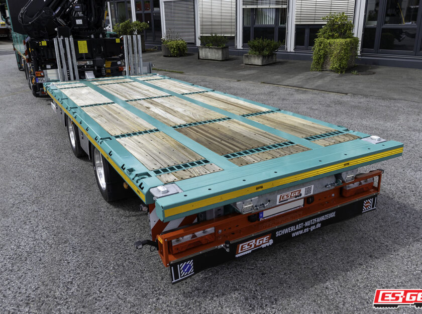 Kompletter Zug mit LKW mit Ladekran und Tandemanhänger der Marke ES-GE für Colossus Logistics. Ladefläche des Tandemanhängers im Fokus.