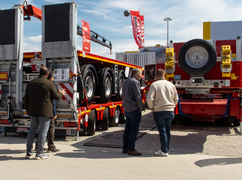 Besucher auf dem Messestand der ES-GE auf der BAUMA 2025. Auflieger im Hintergrund.
