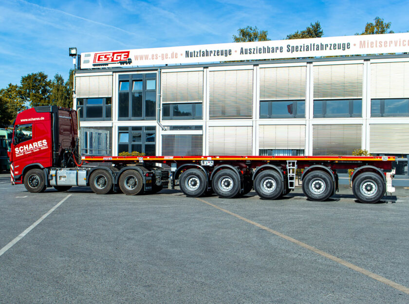 Sattelzugmaschine mit aufgesatteltem MAX Trailer MAX410 Ballastauflieger mit fünf Achsen,  aufgenommen von der Fahreseite. Der komplette Zug steht hinter dem Hauptgebäude der ES-GE.