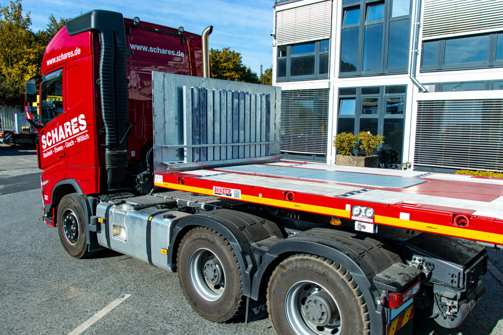 Sattelzugmaschine mit aufgesatteltem MAX Trailer MAX410 Ballastauflieger mit fünf Achsen. Ansicht der vorderen Ladefläche, inkl. Rungenmagazin hinter der Stirnwand.