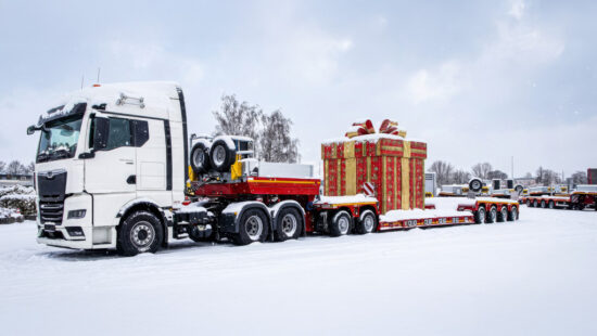 3-achsige Sattelzugmaschine mit einer 2+4-Tiefbettkombination auf dem verschneiten Gelände der ES-GE. Im Hintergrund weitere schneebedeckte Nutzfahrzeuge