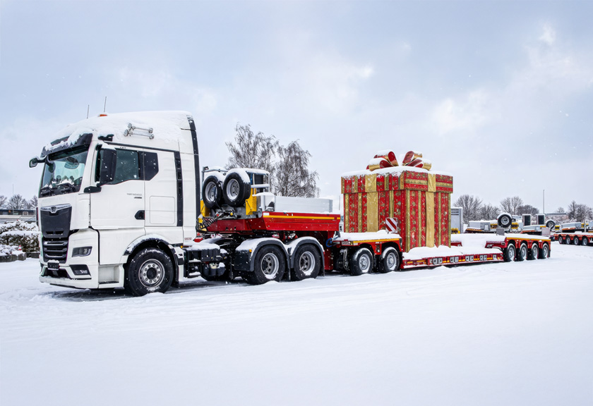 3-achsige Sattelzugmaschine mit einer 2+4-Tiefbettkombination auf dem verschneiten Gelände der ES-GE. Im Hintergrund weitere schneebedeckte Nutzfahrzeuge | A 3-axle tractor unit with a 2+4 low-bed combination on the snow-covered grounds of ES-GE. More snow-covered commercial vehicles are visible in the background.